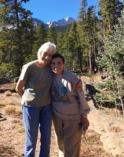 Claire hugs her high school friend in the woods.