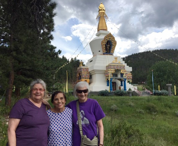 three women stand in front of the Shambhala Center.