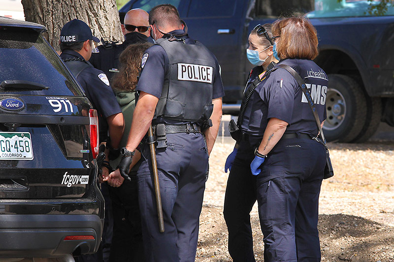 police and community paramedics talk to a person in a behavioral health crisis on the streets in Fort Collins.