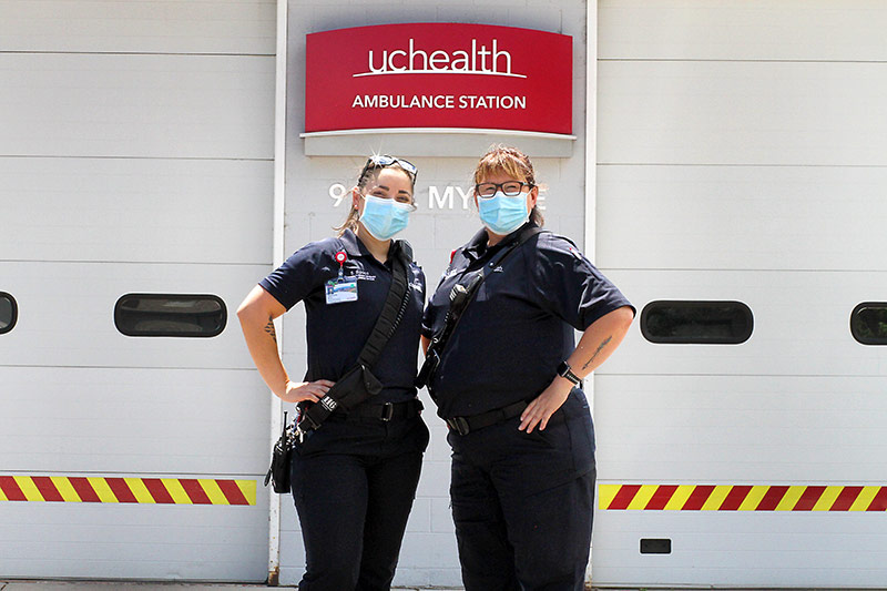 two community paramedics stand outside their UCHealth station.