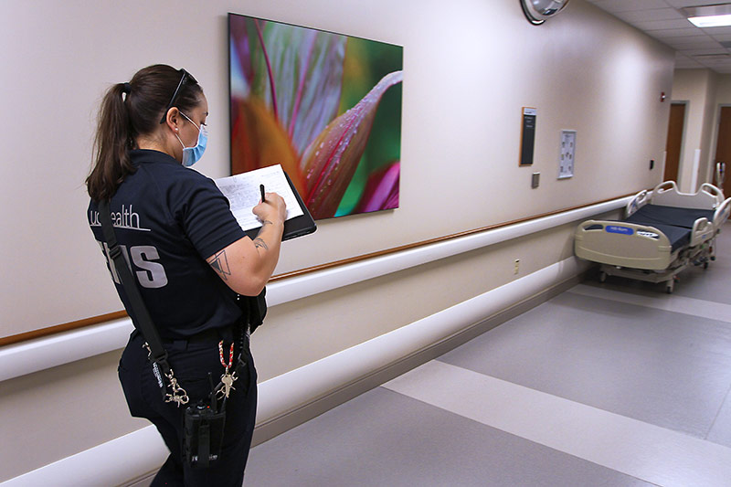 UCHealth community paramedic fills out a mental health hold paperwork in the hallway of Poudre Valley Hospital.