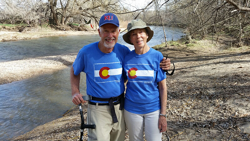 Dave with his arm around his wife at the poudre river, both wearing colorado shirts. It wasn't until about four years ago that Voni was diagnosed with vascular dementia and Dave started to seek tools for caregivers.