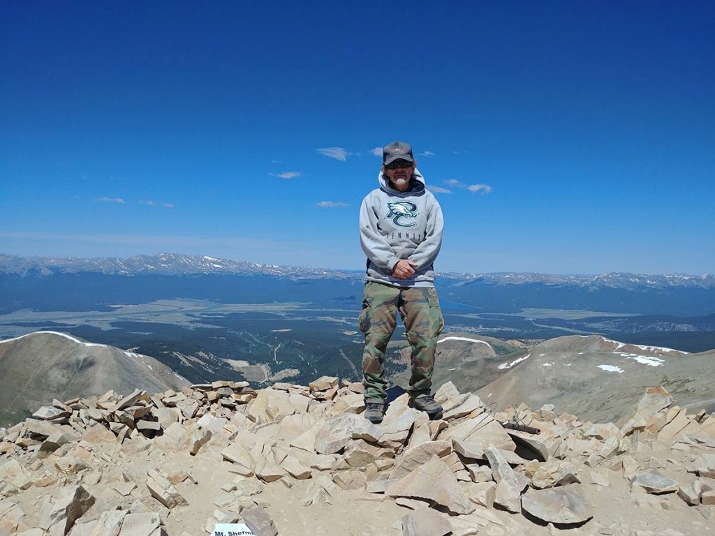 Keith Cunningham at the summit of Mt. Sherman. He made the climb with the help of tiny telescopes mounted to his glasses that allowed him to see roughly 50 to 75 feet ahead.