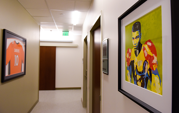 new medical center Cherry Creek - A painting of Muhammad Ali and a Broncos jersey decorate walls.