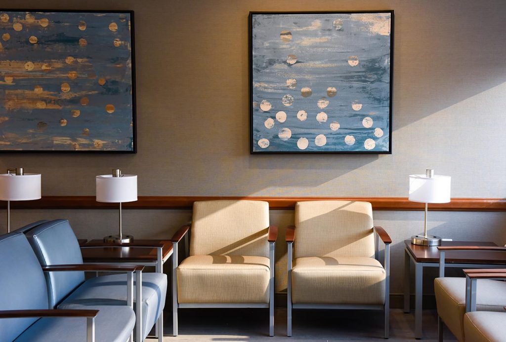 A waiting room with chairs and art in the UCHealth Cherry Creek Medical Center.