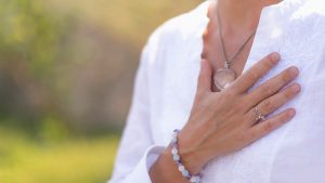 women with her hand on her heart as she practices Three Good Things tool.