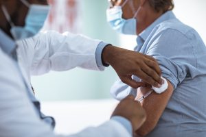 A provider administers a vaccination to a patient in this photo.