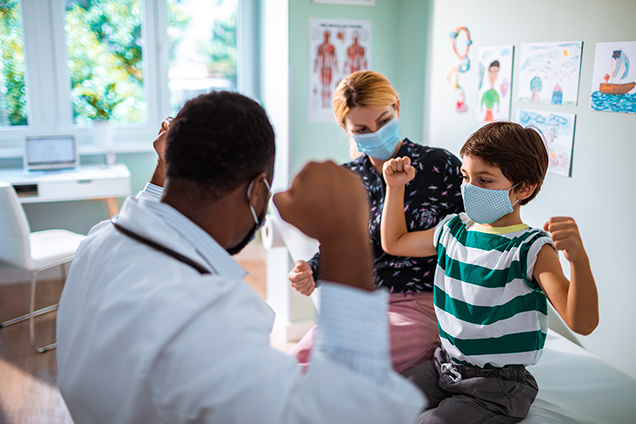 doctor with a pediatric patient and mom addressing medical issues now before COVID and flu season collide.