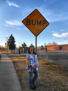 Abby Zamora has loved having certified nurse-midwives for all of her births. Here, she poses pregant with a Bump sign.