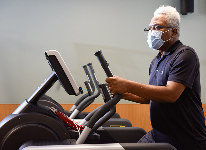 Clarence Troutman working out on a stair stepper. He's dealing with long-term symptoms of COVID-19, a group of patients who identify themselves as COVID-19 'long-haulers.'