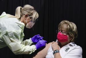 A nurse administers a shot to a woman during a COVID-19 vaccine trial in northern Colorado..