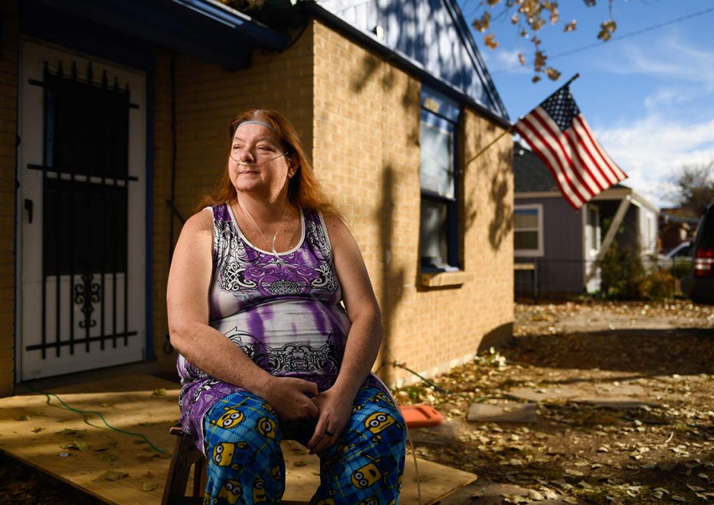 Norma Armistead sits outside her home.