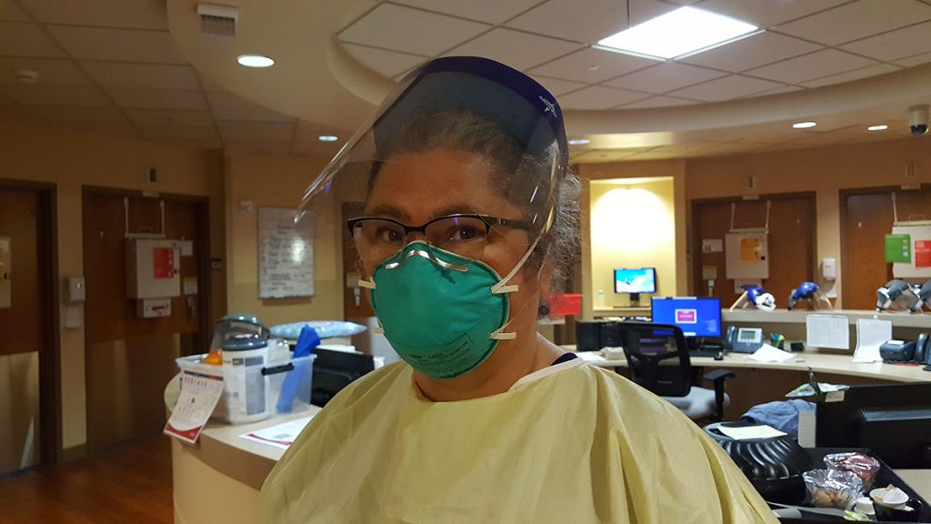 A photo of Patti Loper in a mask at UCHealth Memorial Hospital Central, who has moved from a desk to patient care to help with the increase in COVID-19 patients.