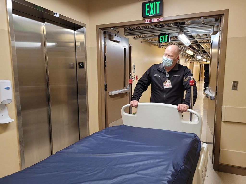 Derek Susa, an associate clinical engineer, moves ICU beds to ready it for more COVID-19 patients.