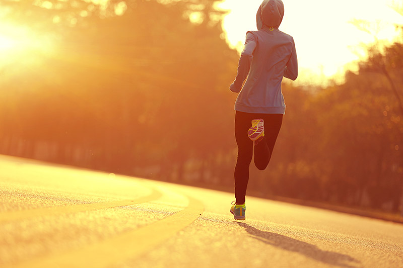 woman running into the sun, getting her vitamin D, which may help against COVID-19.