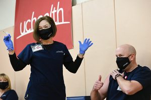 Tamara Dunseth Rosenbaum, chief nursing officer at UCHealth Memorial Hospital, gives the first COVID-19 shot to Jeremy Hulsker, a charge nurse at Memorial.