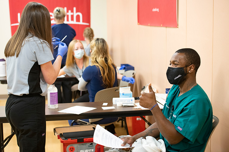 Tre Williams, an environmental services worker at UCHealth Memorial Hospital, gives a thumbs up after receiving the vaccine.
