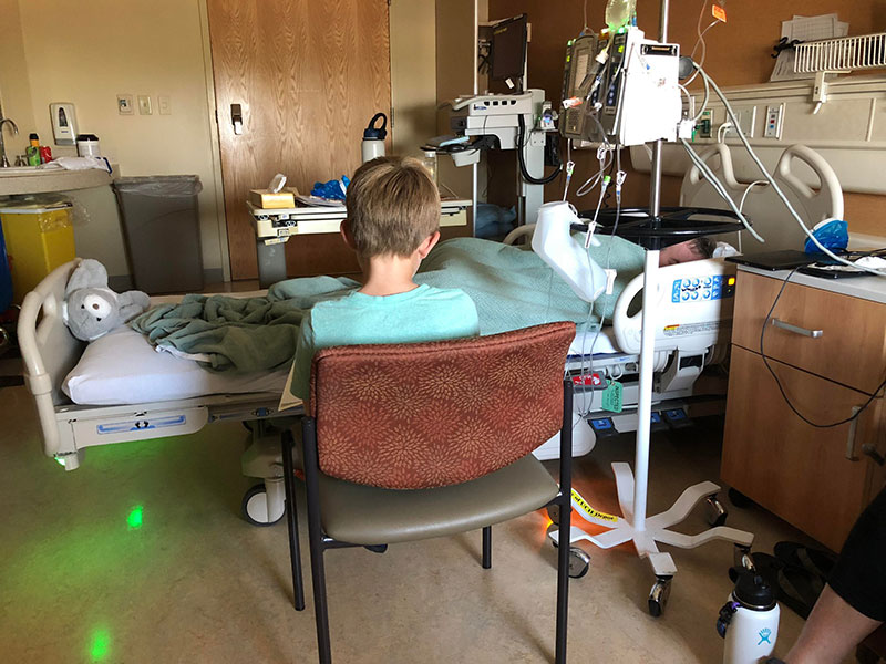 Boden Keller reading "Calvin and Hobbes" to his father, Garry Keller, while he was in the hospital for treatment mucosal melanoma.