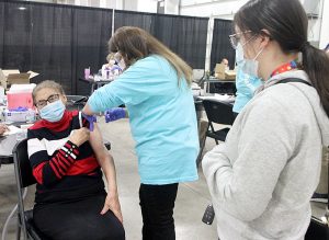 Adela Garcia, 83, a member of the Hispanic community inGreeley, Colorado, gets her COVID-19 vaccine, while her granddaughter, Marahi Lupio, watches.