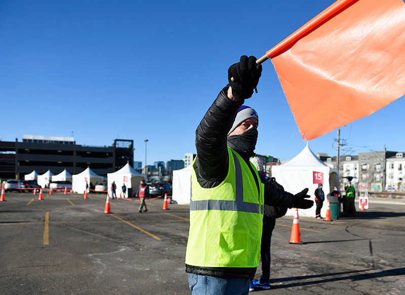 Dick Monfort, owner of the Colorado Rockies, volunteered as a flagger during a mass vaccination event in a Coors Field parking lot over the weekend in Denver.