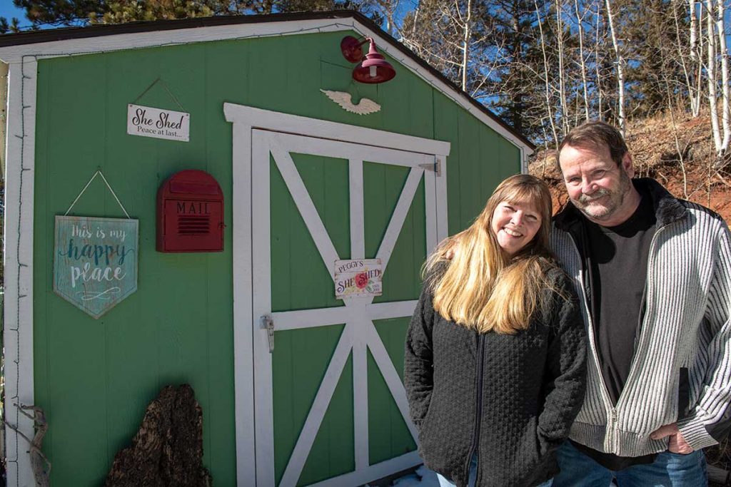 Charlie Chambers and his wife, Peggy, stand outside a 'she shed' he built for her. Peppy is the lead character in his COVID-19 story.