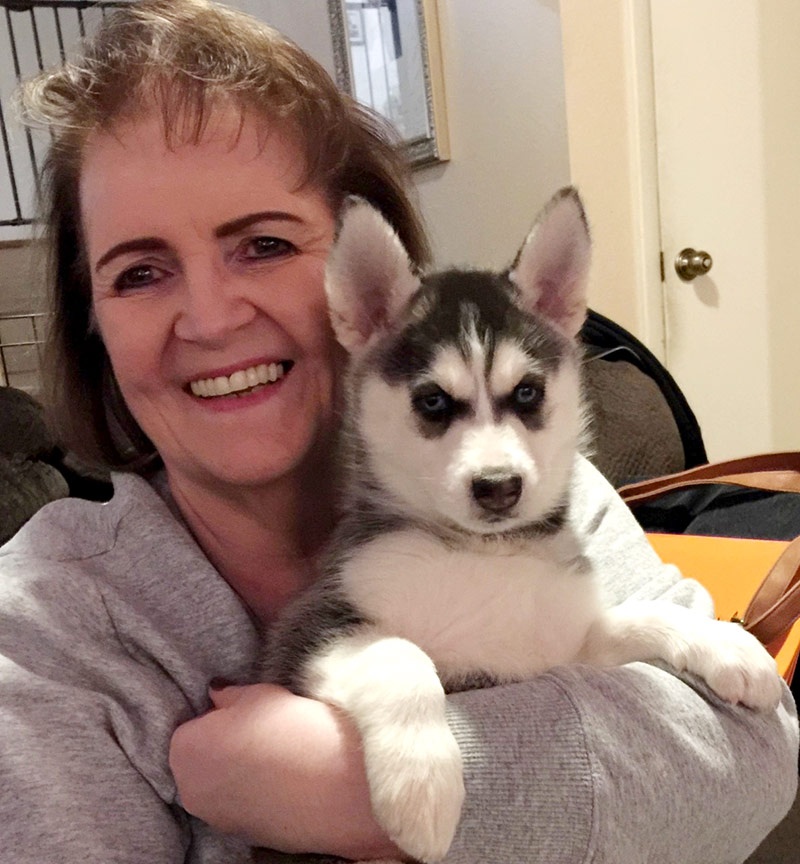 Deb holding her sister's huskie as a puppy. Having the dog forget her because she hadn't seen them so long while in the hospital was just one fear she had about her life after COVID-19.