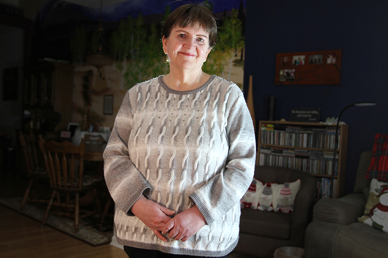 Deb Hoffman stands in her living room as life after COVID-19 continues.