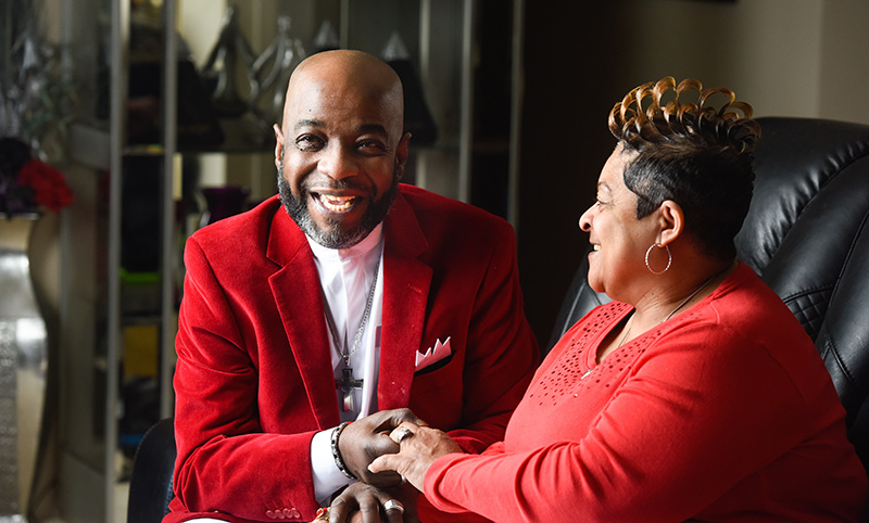 Singing after COVID-19. Michael Peoples and his wife, Shelia, like to dress in matching outfits. Here, he wears a red suit jacket and she's in a red sweater.