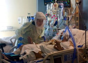 Logan performs therapy with a patient in the ICU.