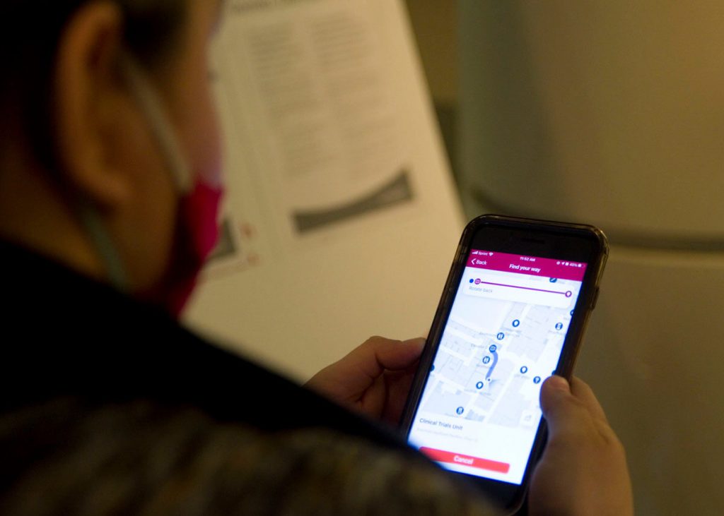 Iliana Hernandez looks at the hospital wayfinding app map on her phone to get around UCH.