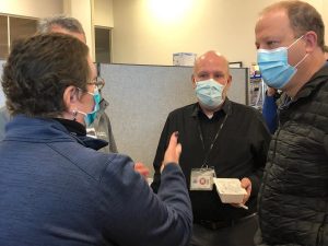 Carolyn Carroll Flynn speaks with Colorado Gov. Jared Polis at a vaccine clinic.