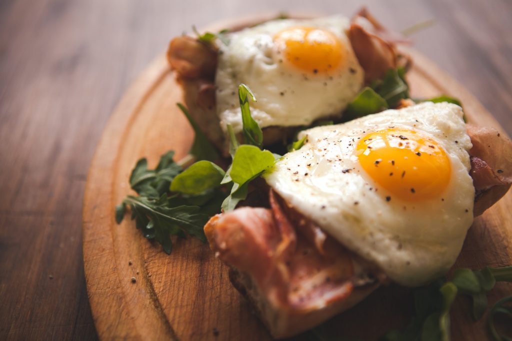 Here, we see fried eggs on a baguette with ham for this article about how to cook eggs.