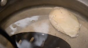 a poached egg cooking in a pot.