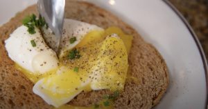 in how to cook eggs this perfect poached egg is laid on a piece of wheat toast.