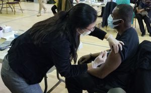 Dr. Hillary Lum, a geriatric medicine physician at the UCHealth Seniors Clinic-Anschutz Medical Campus, administers the Pfizer vaccine to C. Lamont Smith on Feb. 13, 2021, at the UCHealth COVID-19 vaccination clinic at New Hope Baptist Church in Denver. New Hope Baptist Church and UCHealth collaborated with Center for African American Health, Colorado Black Health Collaborative, Mile High Medical Society and the NAACP for the clinic at which 750 people received vaccinations. Smaller clinics operated in partnership with community organizations are a key way UCHealth is working to ensure underserved, vulnerable and minority groups throughout our state have access to the COVID-19 vaccine.