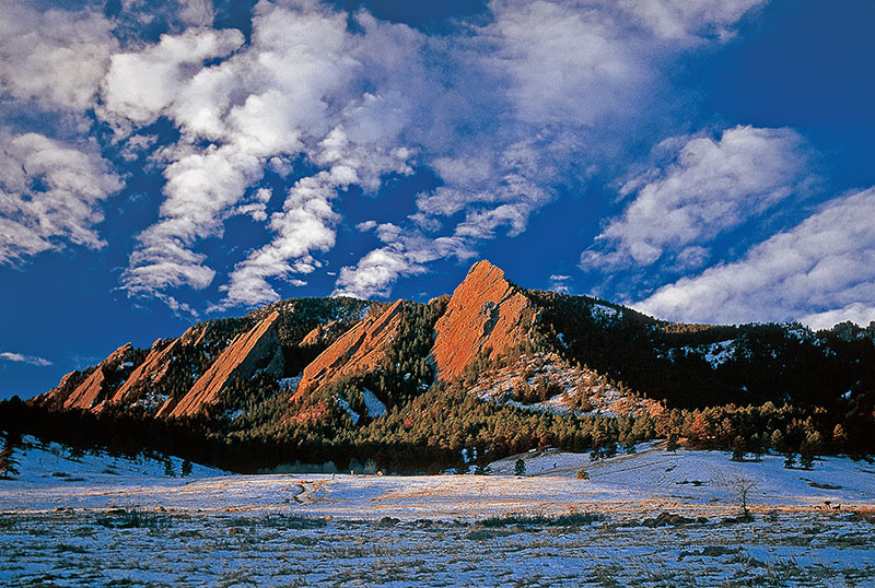Coloradans are reeling after the Boulder mass shooting at a grocery store. This photo shows Boulder's iconic red Flatirons with snow and blue sky. Photo: Getty Images.