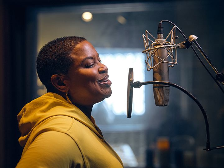 Photo of Neal recording the new evre women's health podcast with a mic.