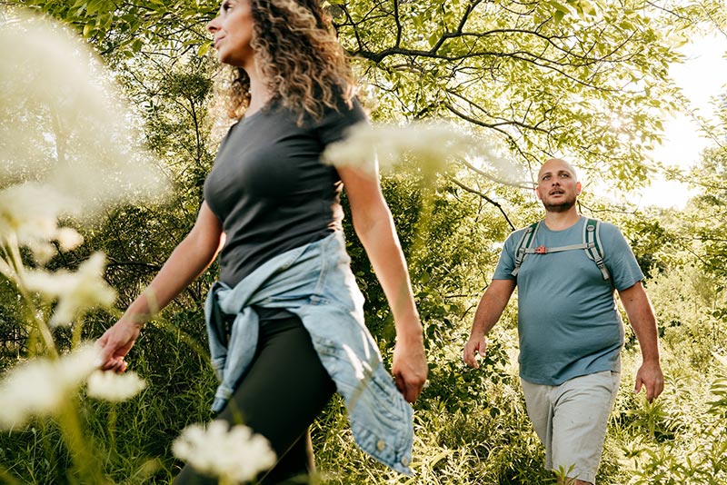 Getting help with sleep can help people lose weight. Here, an overweight man and a woman go hiking.