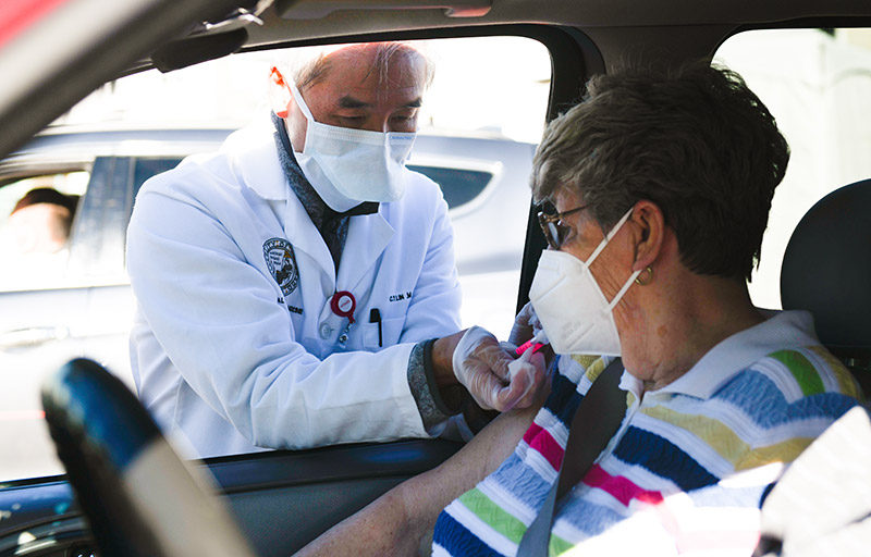 UCHealth doctor gives a person a vaccine during a mass vaccination event at Coors Field on Sunday, January 31, 2021