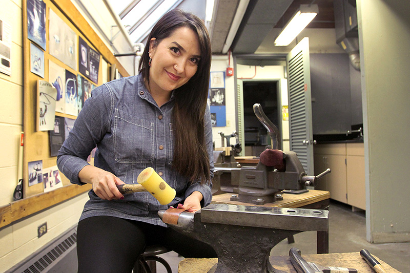 Priscilla Gonzalez doing metalsmithing. Her art demonstrates her efforts for colon cancer awareness.