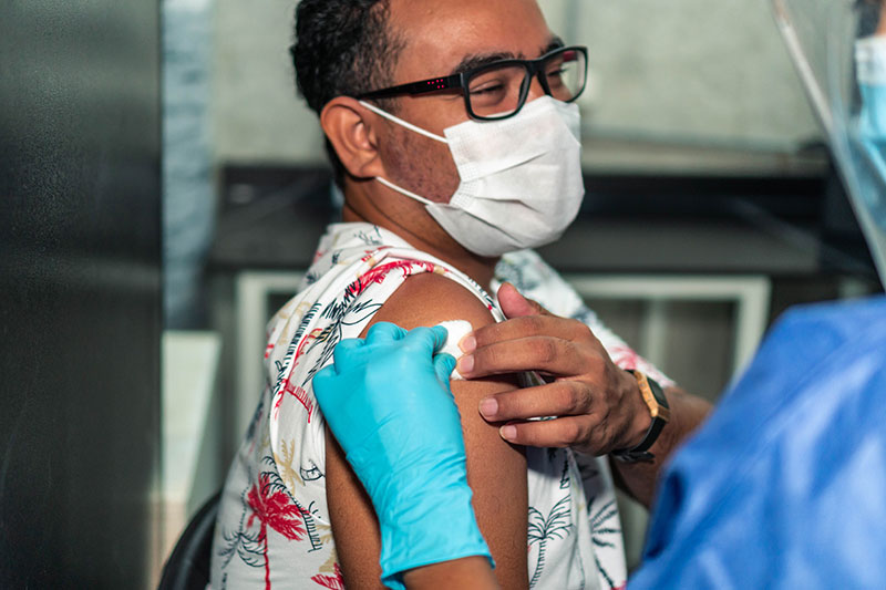 man with autoimmune disease getting a COVID-19 vaccine
