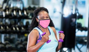 The delta variant and masks. Should you wear a mask indoors again? Here a woman wearing a mask works out in a gym.