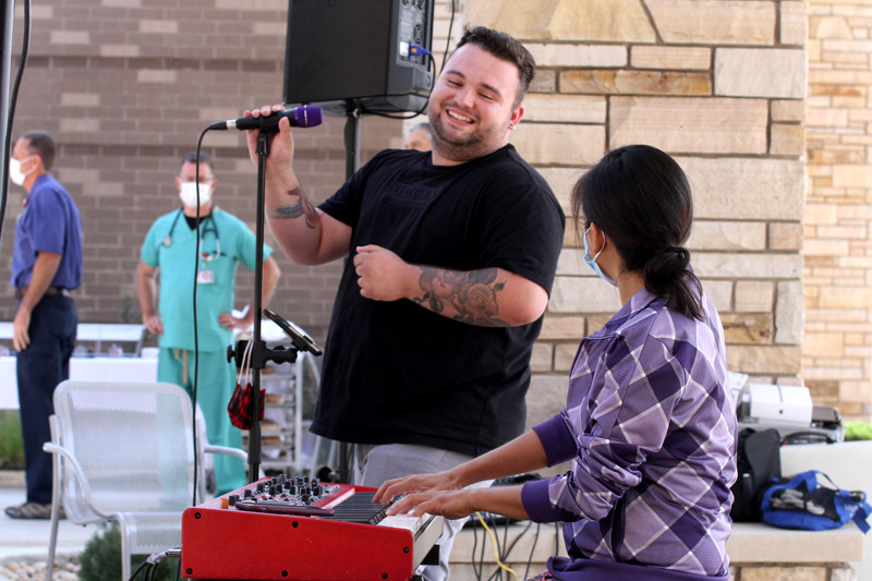 Jacob Larson, a young COVID survivor, sings to health care workers in a hospital courtyard