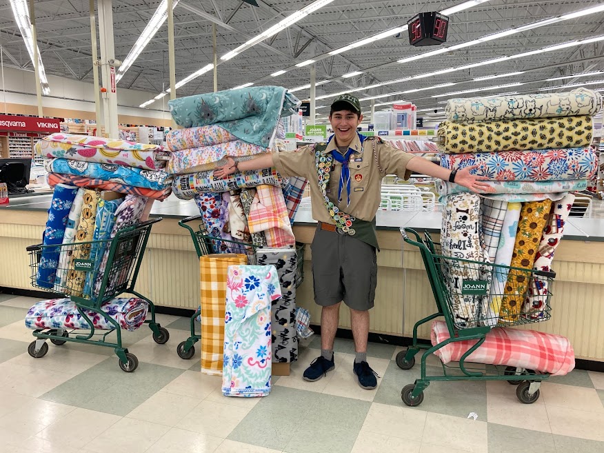 Shane Jewell with three shopping carts filled with material for blankets for his Eagle Scout project idea.