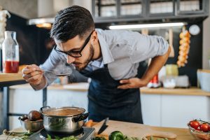Chef smells food as he cooks. How to regain your sense of taste and smell after COVID-19.