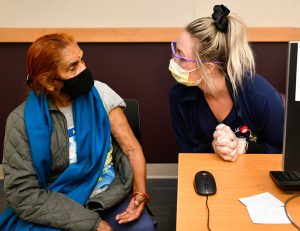 Who should get COVID-19 booster shots. An older woman gets her vaccine at UCHealth Universtiy of Colorado Hospital in Aurora.