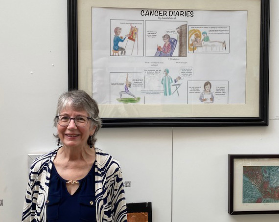 Jeanette Minnich in front of her cartoon cancer art displayed in Washington DC.