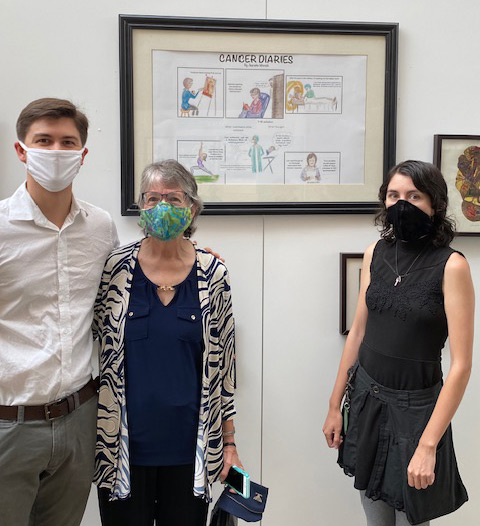 Jeanette Minnich stands with her son, Jonathan and daughter, Venetia in front of her cancer diary display in Washington, D.C.