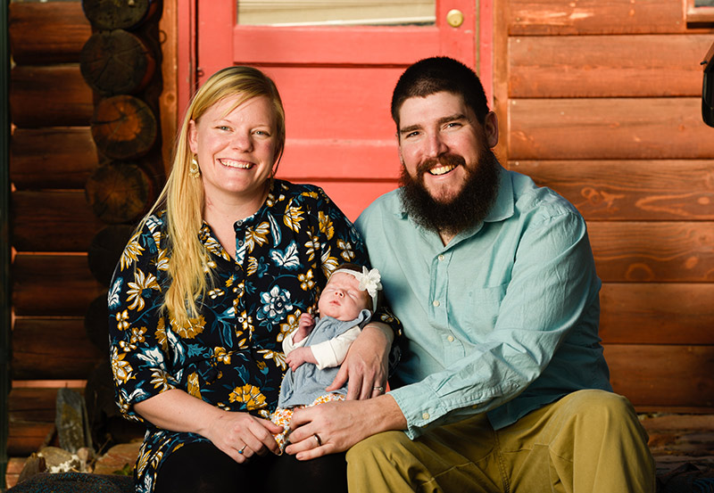 Andrew, Sarah and Kabrini Mays posing outside their log home. Photo by Cyrus McCrimmon for UCHealth.