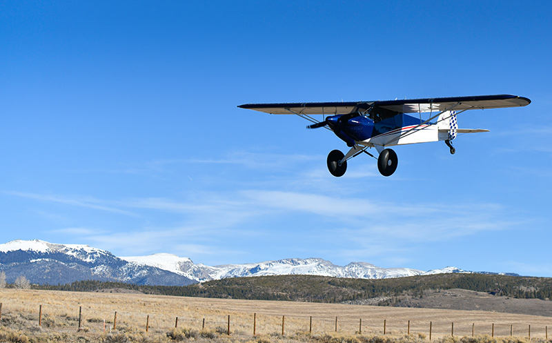 A small plane with mountains in the background.